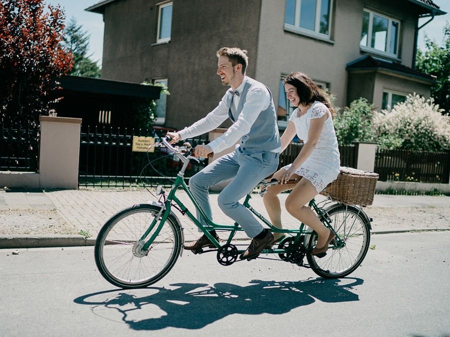 Lustiges Hochzeitsporträt des Brautpaars auf dem Fahrrad