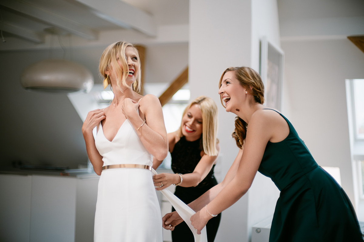 Braut und Freundinnen beim Ankleiden