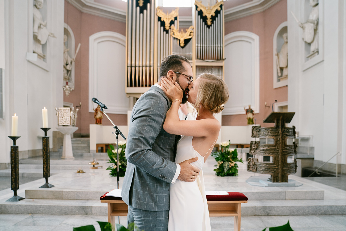Brautpaar küsst sich in Kirche.
