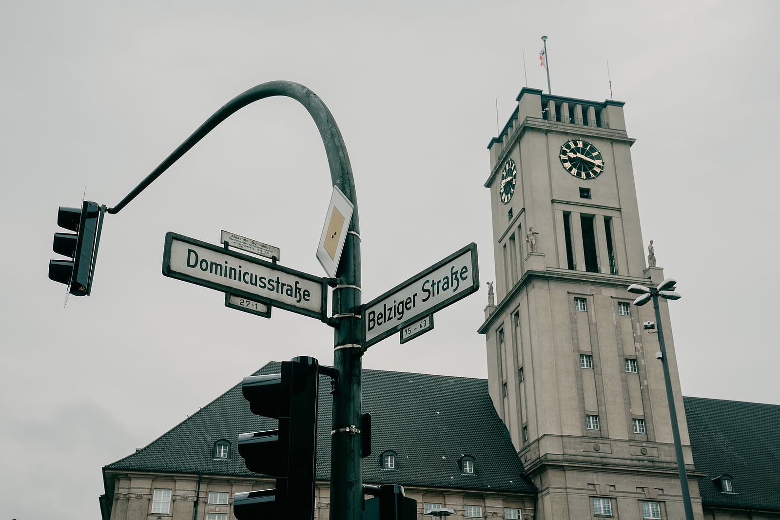 Uhrturm des Rathauses Schöneberg hinter den Straßenschildern der Dominicusstraße und Belziger Straße.