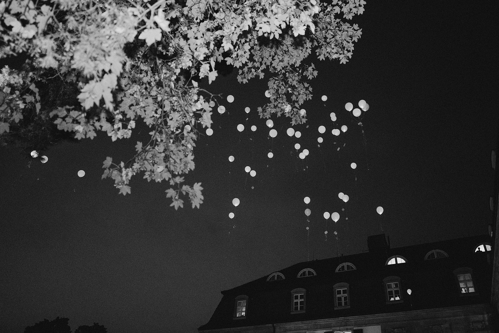 Weiße Luftballons steigen über dem Dach des Schlosshotels Berlin in den Nachthimmel.