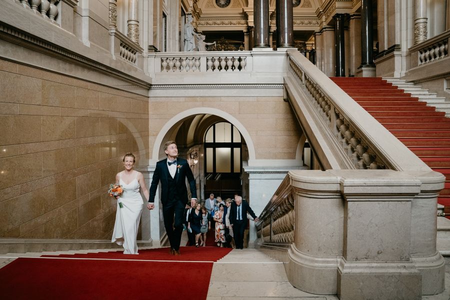 Hochzeitsfotograf für Standesamt & kleine Hochzeiten in Hamburg 13 Brautpaar mit Hochzeitsgästen auf der Treppe im Hamburger Rathaus