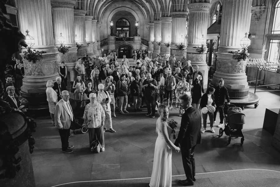 Hochzeitsfotograf für Standesamt & kleine Hochzeiten in Hamburg 26 Brautpaar mit Hochzeitsgästen in der Eingangshalle des Hamburger Rathauses nach der Trauung