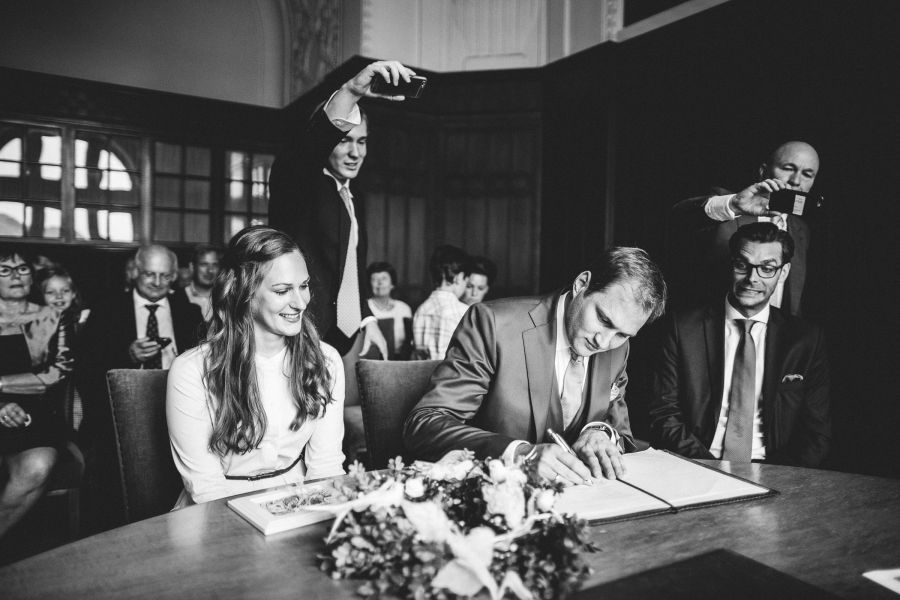 Bräutigam unterschreibt während der standesamtlichen Hochzeit im Neuen Rathaus Hannover